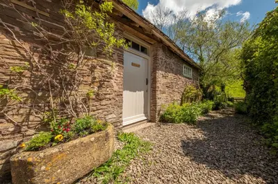 a brick house with a white door on it at The Garden Barn in Peterchurch