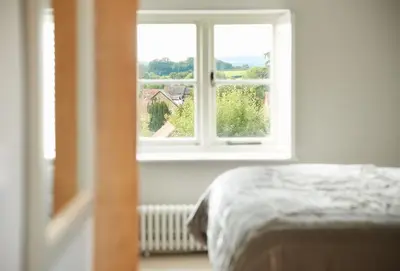 a bedroom with a bed and a window at Unconformity Barn in Hope Bowdler