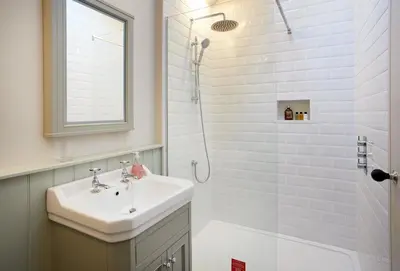 a white bathroom with a sink and a shower at The Groom's Flat in Leominster