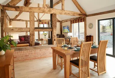 a kitchen and dining room with a wooden table and chairs at Evenwood Gables in Kenley
