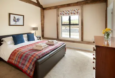 a bedroom with a large bed and a window at Evenwood Gables in Kenley