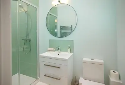a bathroom with a shower and a sink and a mirror at Evenwood Gables in Kenley