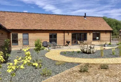 a log cabin with a garden in front of it at Evenwood Gables in Kenley