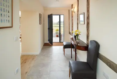 a hallway with a table and chairs and a door at Evenwood Granary in Kenley