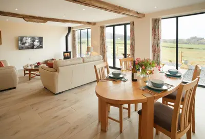a living room with a wooden table and a couch at Evenwood Granary in Kenley