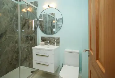 a bathroom with a toilet and a sink and a mirror at Evenwood Granary in Kenley