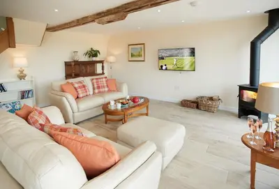 a living room with white furniture and a fireplace at Evenwood Granary in Kenley
