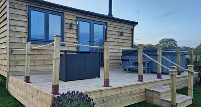 a cabin with a wooden deck with a fence at Wye Valley Cabin in Upper Welson