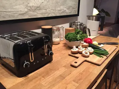 a cutting board with vegetables and a toaster on a counter at The Shippen - Open-plan barn conversion, high-spec, stunning views in Norbury