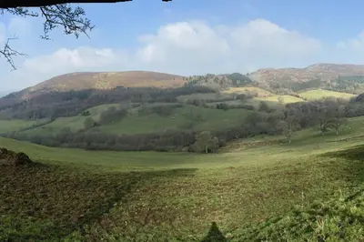 a green field with a mountain in the background at The Shippen - Open-plan barn conversion, high-spec, stunning views in Norbury