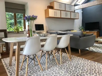 a living room with a table and chairs and a couch at The Shippen - Open-plan barn conversion, high-spec, stunning views in Norbury