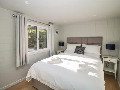 a bedroom with a large white bed and a window at Little Shelve Barn in Shrewsbury