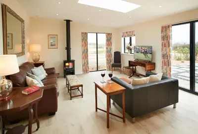 a living room with a couch and a table at Evenwood Byre in Kenley