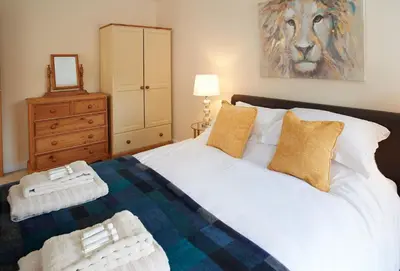 a bedroom with a bed and a painting of a lion at Evenwood Byre in Kenley