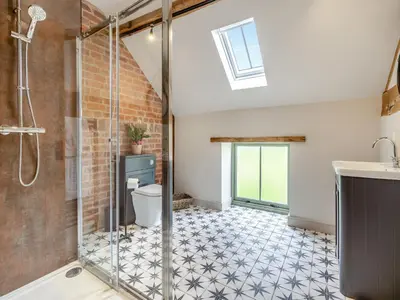 a bathroom with a shower and a toilet and a sink at The Dairy - Uk44130 in Baystonhill