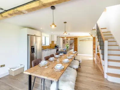a kitchen and dining room with a long wooden table at The Stables - Uk44139 in Baystonhill