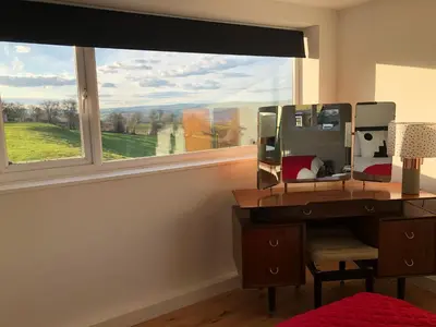 a bedroom with a desk and a large window at The Living Energy Holidays in Velindre