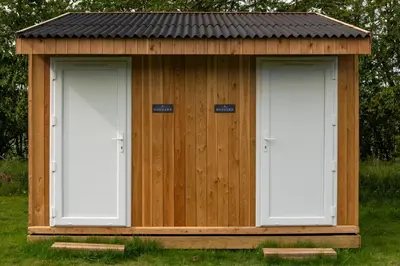 a wooden shed with two doors in the grass at 3 Bed in Talybont-on-Usk oc-wal374 in Talybont