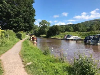 a boat on a river next to a path at 3 Bed in Talybont-on-Usk oc-wal374 in Talybont