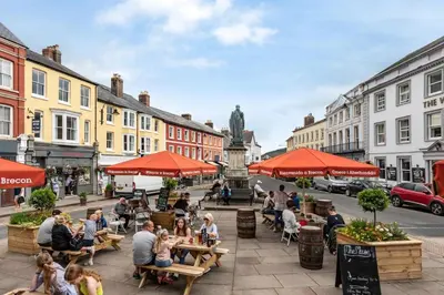 a group of people sitting at tables on a city street at 3 Bed in Talybont-on-Usk oc-wal374 in Talybont