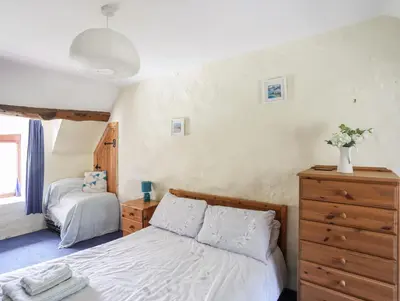 a bedroom with a white bed and a dresser at Gilfachwydd in Dolgellau