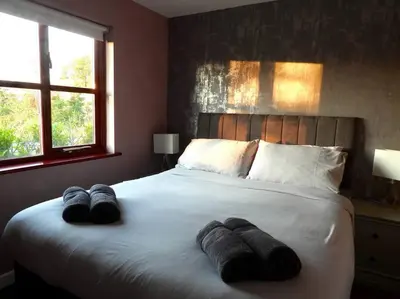 a bedroom with a large bed with towels on it at Nature's Oasis: Pet-Friendly Snowdonia Cottage in Trawsfynydd