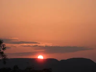 a sunset with the sun setting over the mountains at Nature's Oasis: Pet-Friendly Snowdonia Cottage in Trawsfynydd