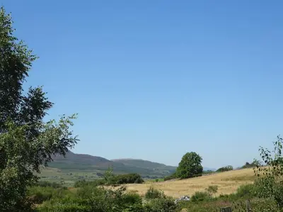 a view of a field with trees and hills at Nature's Oasis: Pet-Friendly Snowdonia Cottage in Trawsfynydd