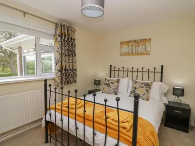 a bedroom with a bed and a window at Erwlon in Aberystwyth