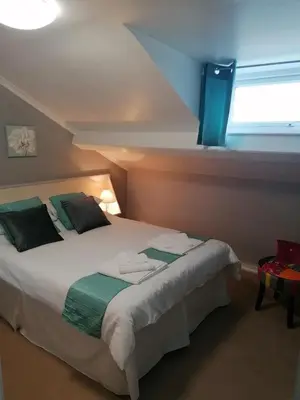 a bedroom with a large bed with a window at The George Borrow Hotel in Ponterwyd
