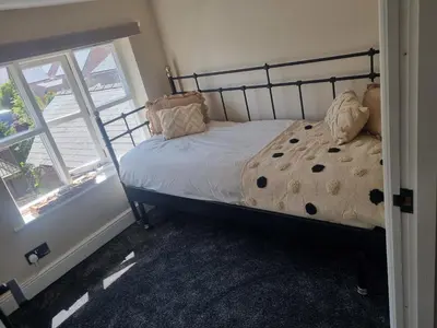 a bedroom with a bed and two windows at Grade ll listed holiday home in Llanidloes