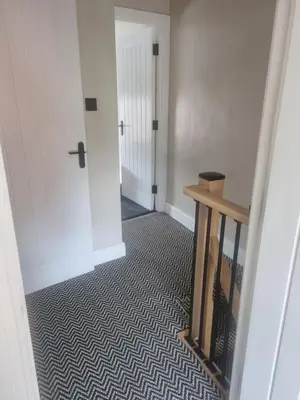 a hallway with a stairway with a door and a stair at Grade ll listed holiday home in Llanidloes