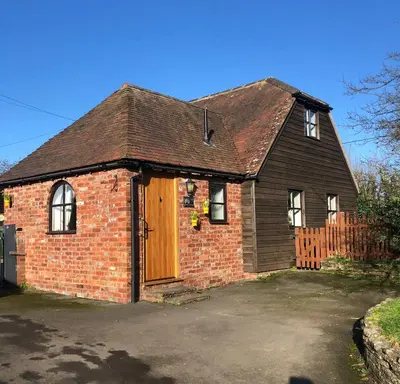 an old brick house with a wooden door at The Annexe at Walnut Tree Cottage in Hope under Dinmore