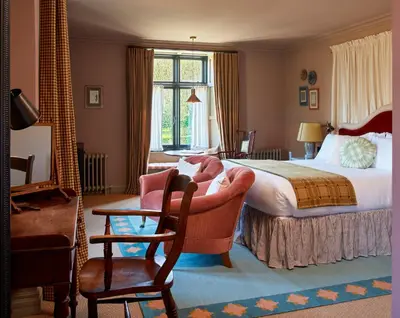 a hotel room with a bed and a chair at Penmaenuchaf Hotel in Dolgellau