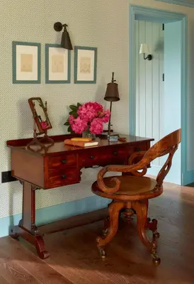 a wooden desk with a vase of pink flowers on it at Penmaenuchaf Hotel in Dolgellau