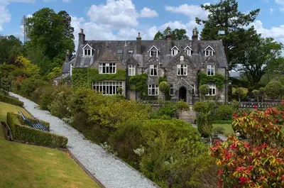an old house with a garden in front of it at Penmaenuchaf Hotel in Dolgellau