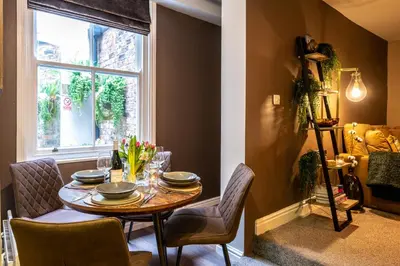 a dining room with a table and chairs and a window at At Home Apartments in Shrewsbury