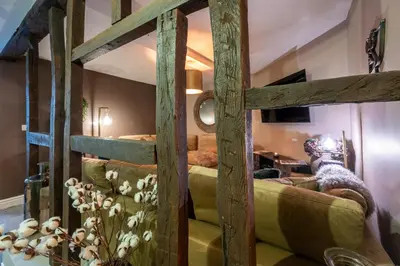 a wooden bed in a room with a couch at At Home Apartments in Shrewsbury