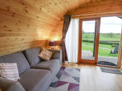 a living room with a couch and a large window at Pine Lodge in Llangadog