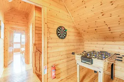 a log cabin with a stove in a room at Robin Lodge in Llanbedr