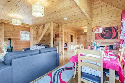 a living room with a blue couch and a table at Robin Lodge in Llanbedr