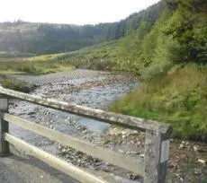 a bridge over a river on the side of a road at Belle Vue Hotel in Llanwrtyd Wells