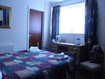 a bedroom with a bed and a window and a sink at Belle Vue Hotel in Llanwrtyd Wells