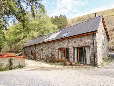 a stone house with skylights on top of it at Ysgubor Craig Y Gronfa in Machynlleth