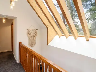 a room with a wooden staircase with a large window at Ysgubor Craig Y Gronfa in Machynlleth