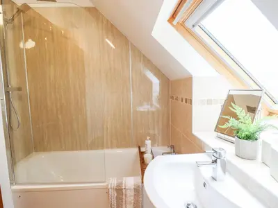 a bathroom with a bath tub and a sink at Ysgubor Craig Y Gronfa in Machynlleth