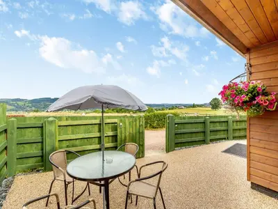 a table and chairs with an umbrella on a patio at The Stables in Forden