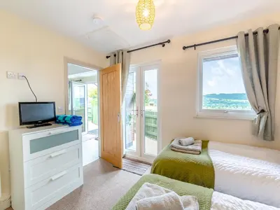 a bedroom with a bed and a tv and a window at The Stables in Forden