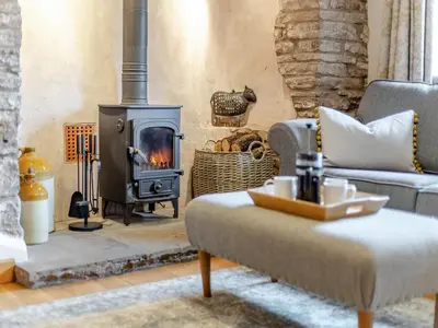 a living room with a wood burning stove at The Cider House in Clee Saint Margaret