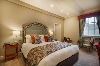 a bedroom with a large bed and a window at The Wynnstay Hotel, Oswestry, Shropshire - The Coaching Inn Group in Oswestry